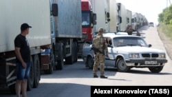 Камиони чакат да преминат контролно-пропускателния пункт Армянск между област Херсон и Крим на 23 юни. Снимката е направена един ден след като мостът Чонгар беше повреден при ракетен удар и затворен за движение.