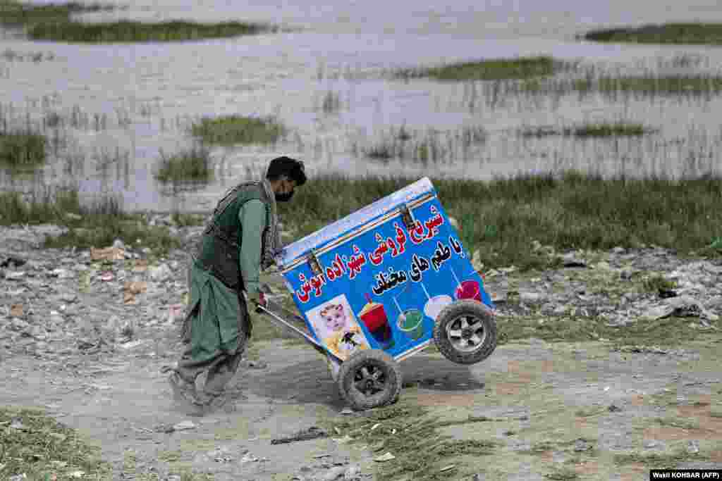 An Afghan vendor pushes his ice-cream cart as he looks for customers near Shuhada Lake in Kabul.