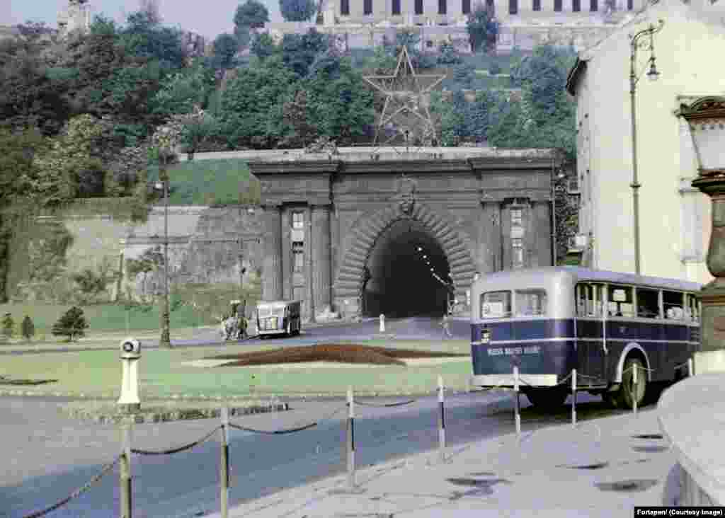 Tunel Budimskog zamka sa zvezdom se vidi na ovoj fotografiji iz 1958. godine. Crvena zvezda je bila uobičajena u celom Sovjetskom Savezu i u zemljama istočnog bloka, ali, osim u Moskovskom Kremlju, njeno postavljanje na zgrade je bilo relativno retko, čak i u staljinističkoj Rusiji. U Budimpešti, međutim, kako pokazuje arhiv Fortepan, čini se da gotovo nijedan poznati spomenik nije ostao bez zvezde. &nbsp;