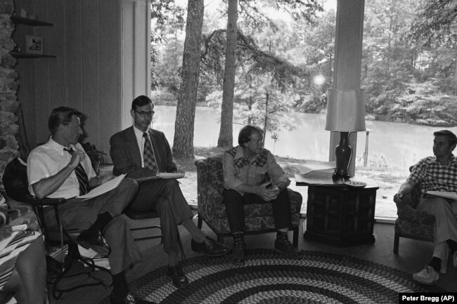 جیمی کارتر حین گفت‌وگو در جلسۀ غیررسمی به‌همراه زبیگنیو برژینسکی و استوارت آیزنستات، به‌ترتیب نفر اول و دوم از سمت چپ