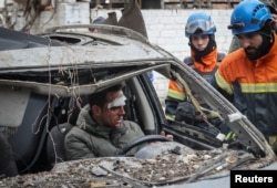 Рятувальники намагаються деблокувати водія автівки, яка потрапила під російський обстріл у центрі Харкова. 2 січня 2024 року