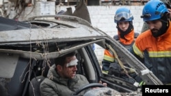 Спасатели разговаривают с раненым в результате российской ракетной атаки. Харьков, 2 января 2024 года