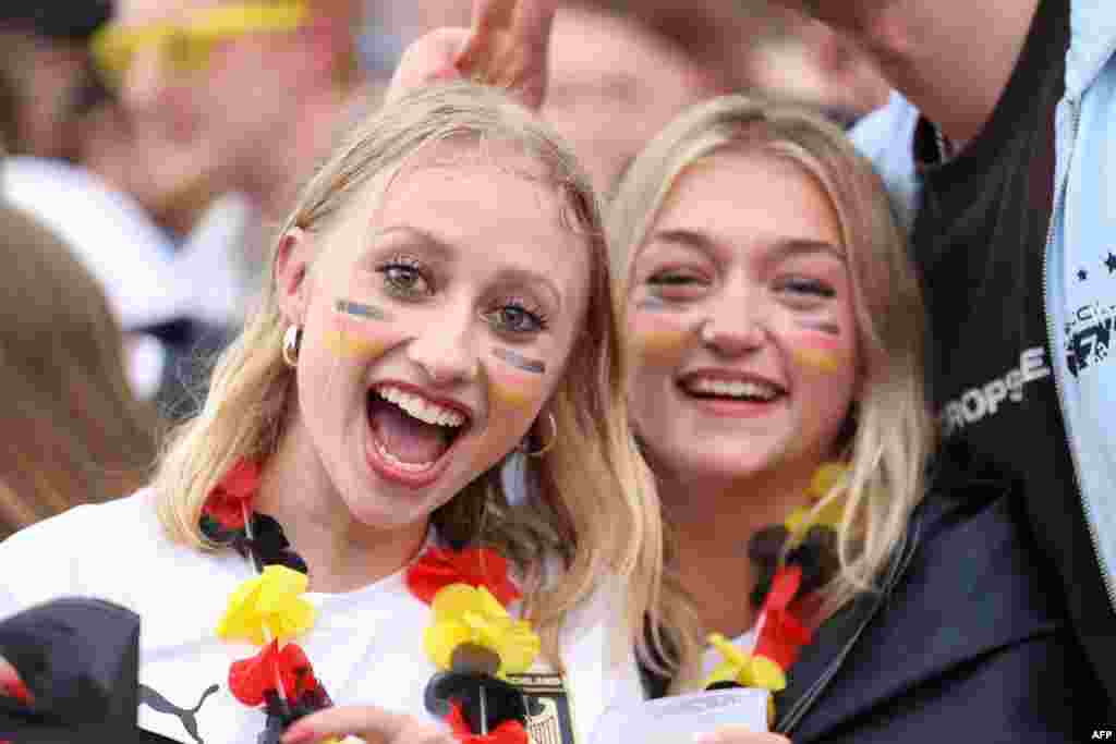 Dy tifoze të kombëtares së Gjermanisë me fytyra të lyera me ngjyrat e flamurit brohorasin për ekipin e tyre i cili doli fitues me rezultat 2-0 kundër Hungarisë.&nbsp;
