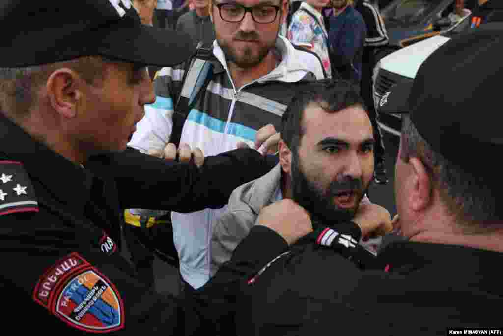A protester clashes with Armenian police officers in Yerevan on September 21. A second war in 2020 saw Azerbaijan reconquer territory in and around the mountainous region and Armenia lose control of the corridor, leaving the road policed by Russian peacekeepers until it was blocked last December.