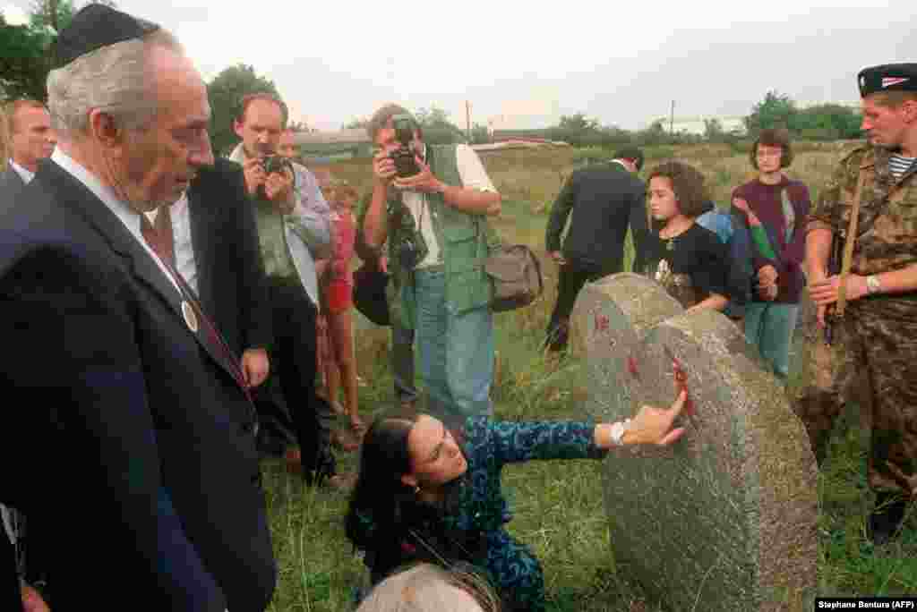 Israel&rsquo;s then-Foreign Minister Shimon Peres visits the grave of his great-grandfather at an abandoned Jewish cemetery in Volozhin, west of Minsk, in August 1992. Peres was born in the village but emigrated as a boy to today&rsquo;s Israel. Decades of tensions between Israel and the Soviet Union had made it nearly impossible for Peres to revisit his home village before 1991.&nbsp;