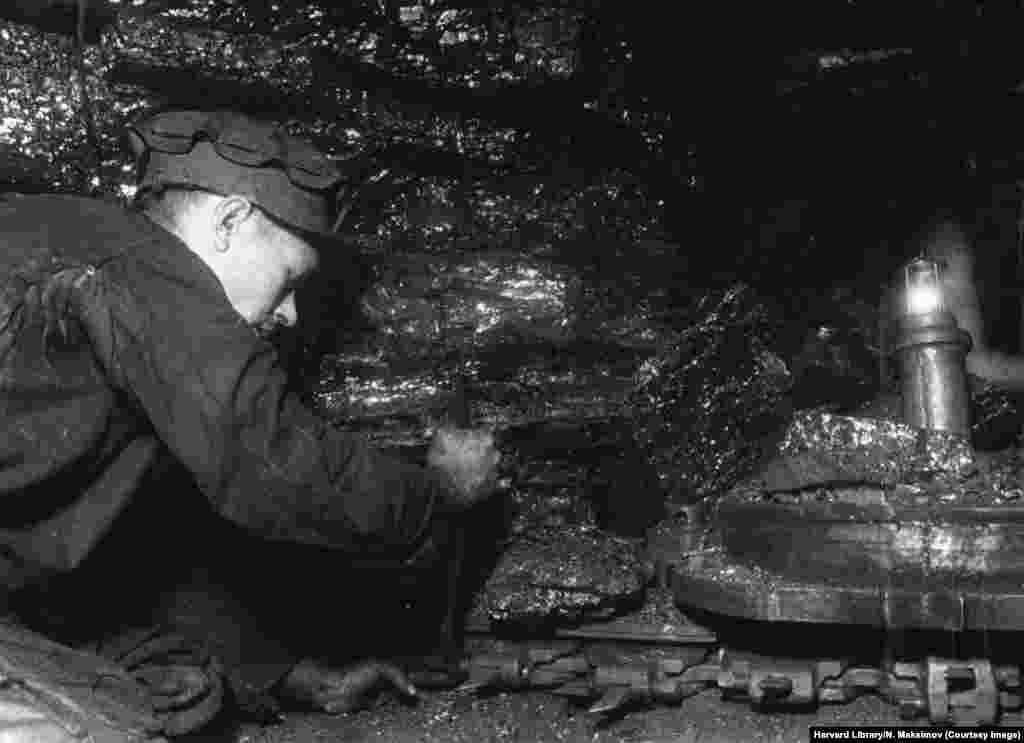 Un miner repară o mașinărie, într-o fotografie din seria intitulată de fotograf: &bdquo;Reluarea mineritului de cărbune în Donbas&rdquo;.