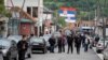 Ljudi šetaju ulicom sa zastavama Srbije u Zubinom Potoku, Kosovo, 31. maja 2023.