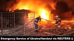 Emergency personnel work to put out a fire following a previous drone attack in Kharkiv, Ukraine, on January 21. 