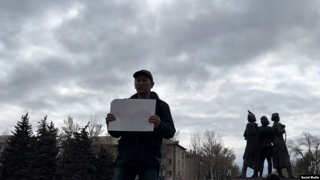 Баллотировавшийся в депутаты мажилиса парламента Казахстана журналист Лукпан Ахмедьяров с плакатом на площади в Уральске. 9 апреля 2023 года