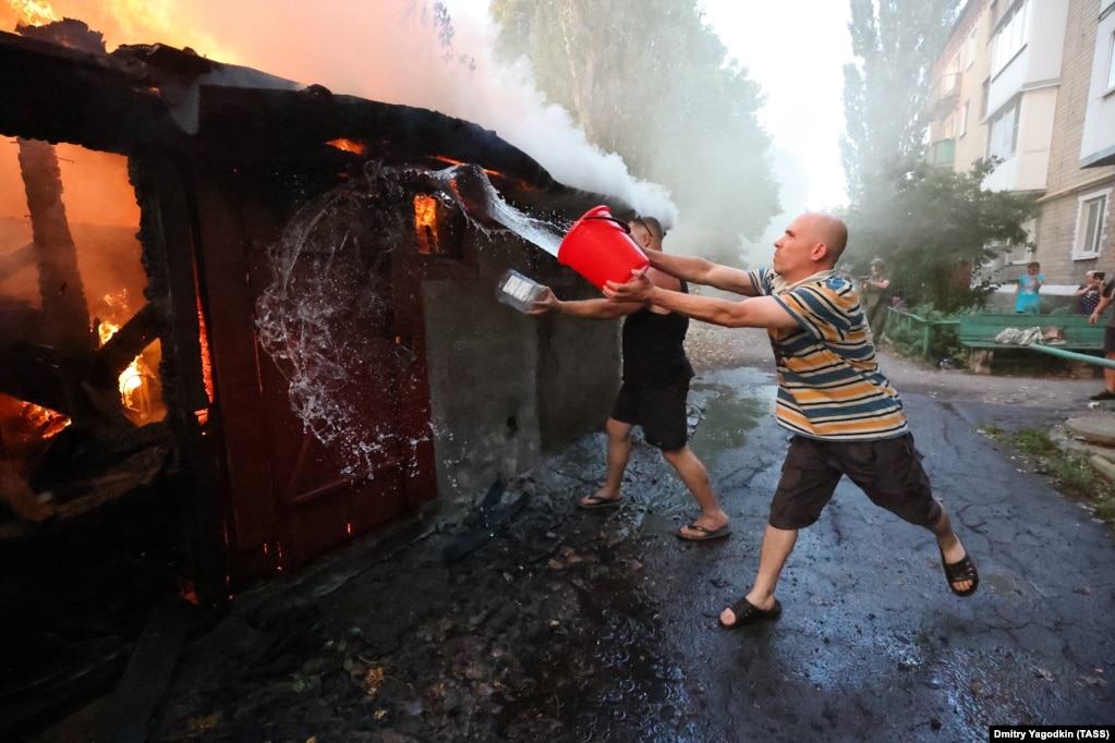 Мъж се опитва да потуши пожар след удари по контролираното от Русия село Лидиевка в района на Донецк. Снимката е 31 август. Киев съобщи, че украинските войници напредват бавно, за да минимизират жертвите си.