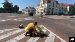 A man covers a dead body after a Russian attack in Chernihiv on August 19.