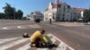 Чоловік прикриває тіло загиблої людини після російської атаки на Чернігів, 19 серпня 2023 року