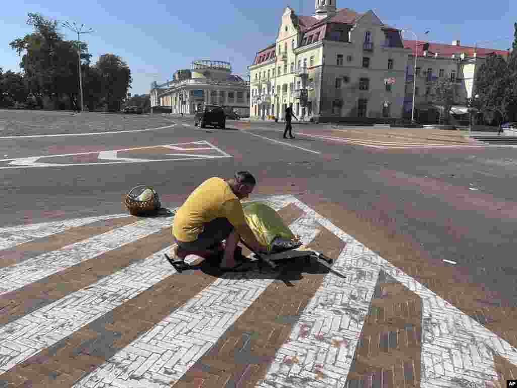 Jedan od civila&nbsp;pokriva tijelo poginule osobe u centru grada.