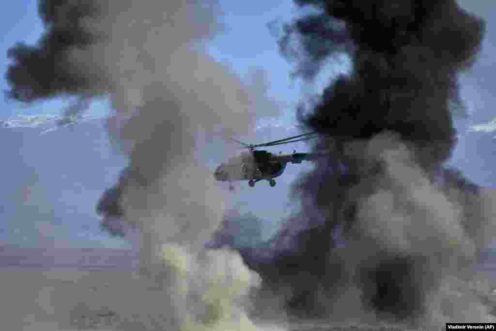 Российский вертолёт Ми-8 пролетает сквозь облака дыма во время учений Организации Договора о коллективной безопасности (ОДКБ) в Кыргызстане, 11 октября 2023 года. Все фото этой галереи были сняты на учениях &laquo;Нерушимое братство&raquo;, которые стартовали 9 октября&nbsp; &nbsp;