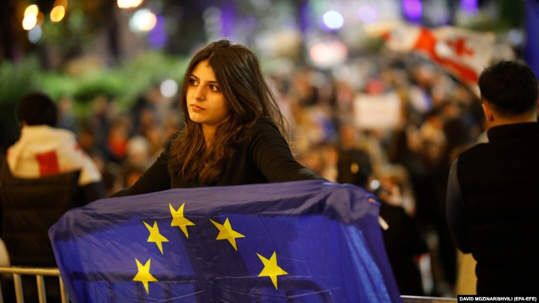 O tânără afișează un steag al UE în timpul unui protest față de legea privind „agenții străini” lângă clădirea Parlamentului din Tbilisi, Georgia, 7 mai 2024. 