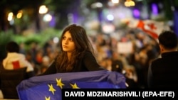 Një grua mban në dorë një flamur të BE-së gjatë protestës kundër projektligjit për "agjentët e huaj" në Tbilisi, Gjeorgji, 7 maj 2024.