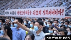 Na fotografiji od 25. juna 2023., stanovnici Pjongjanga drže transparent na kojem piše "Hajde da razbijemo ratnu provokaciju američkih imperijalista i marioneta!" tokom masovnog mitinga povodom obilježavanja 73. godišnjice Korejskog rata, koji je počeo 25. juna 1950. 