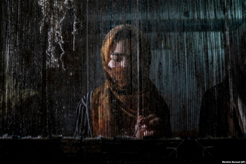 Një grua afgane duke thurur një qilim në një fabrikë qilimash tradicionalë në Kabul.