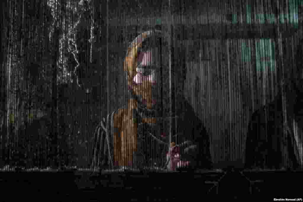 An Afghan woman weaves a carpet at a traditional carpet factory in Kabul.
