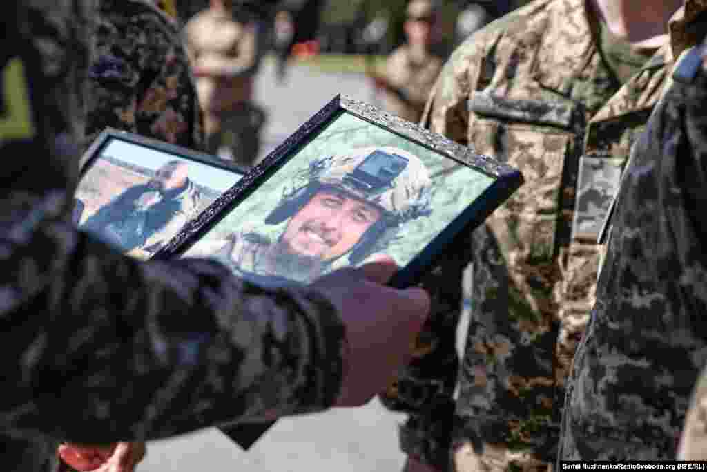 A Ukrainian soldier looks at portraits of his fallen comrades.