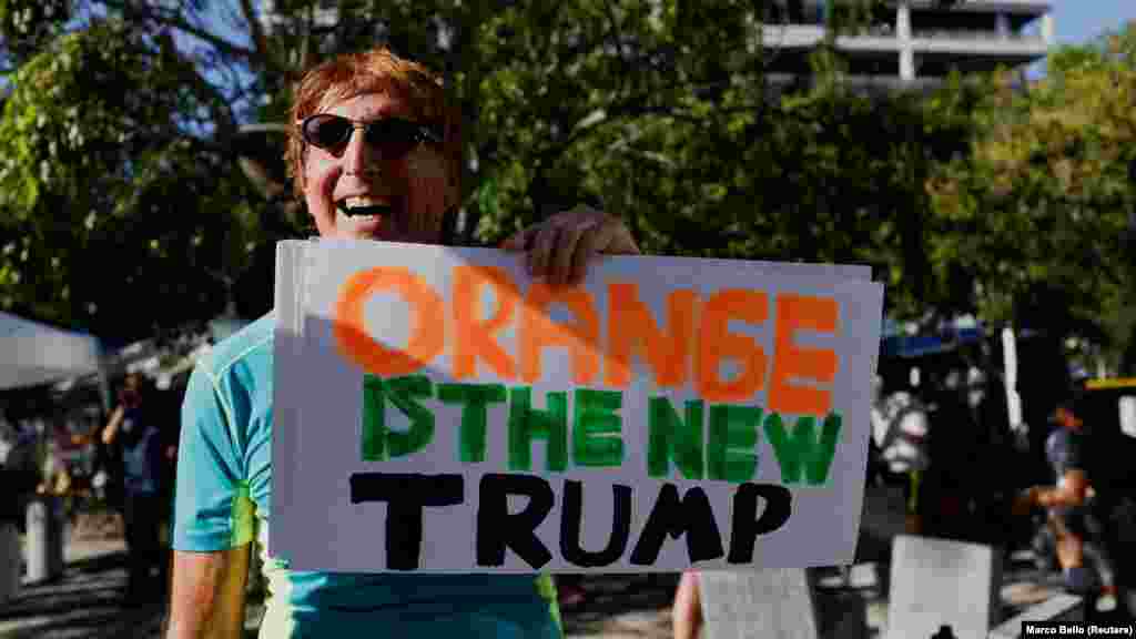 A narancs az új Trump &ndash; áll az egyik demonstráló tábláján, utalva a Donald Trump megválasztását követően elterjedt, egy népszerű sorozat címéből kölcsönzött mondásra, miszerint a narancsszínű bőréről ismert Trump váltja a fekete Obamát