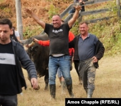 Jovo Vodjeviq Duman ngre duart lart nga gëzimi pasi demi i tij, Misko, fitoi në kategorinë e peshave të rënda.