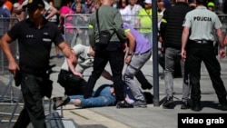 Slovak security officers detain a man suspected of shooting Prime Minister Robert Fico on May 15. 