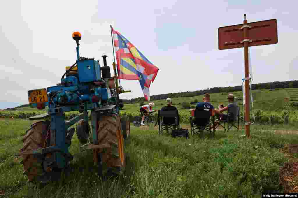 Gledaoci trke pored traktora ukrašenog zastavama, Francuska.