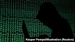 Čovek sa kapuljačom drži laptop računar, 13. maja 2017. Ilustracija