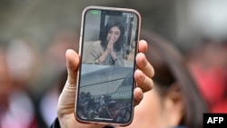 Poziv mobilnim telefonom bivše premijerke Tajlanda Jingluk Šinavatre, sestre Taksina Šinavatre, dok pristalice čekaju ispred aerodroma Don Mueang u Bangkoku 22. avgusta 2023.