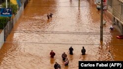 Ljudi hodaju u poplavljenoj ulici Porto Algrea na jugu Brazila, 4. maj 2024.