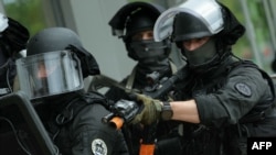 Французские полицейские из элитного штурмового подразделения французской полиции RAID принимают участие в антитеррористических учениях на олимпийском объекте в Вер-сюр-Марн, 30 мая 2024 года