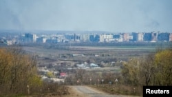 Coloane de fum se ridică deasupra orașului Bahmut după un bombardament, Ucraina, 10 aprilie 2023.