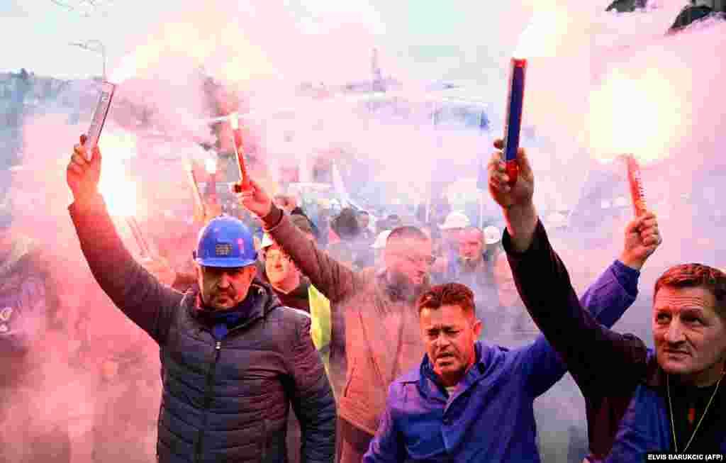 Bosnian coal miners hold flares as they gather near the government building in Sarajevo to protest against the deterioration of working conditions.