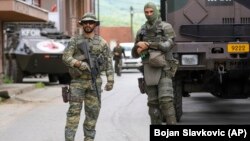 German KFOR soldiers guard the municipal building following clashes between ethnic Serbs and troops from the NATO-led KFOR peacekeeping force in Zvecan, northern Kosovo, on May 30.