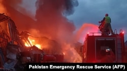 Pakistani firefighters battle a blaze that erupted in a warehouse at a hydropower dam construction site in Khyber Pakhtunkhwa Province on April 4.