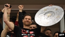 Шаби Алонсо ликува с макет на трофея от Бундеслигата след края на мача между неговия Байер Леверкузен и Вердер Бремен в неделя, спечелен с 5:0. Пет кръга преди края на германския шампионат, отборът на Алонсо е недостижим на първото място.