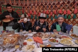 Stërvitësit e shpendëve marrin pjesë tryezën me ushqime tradicionale kazake gjatë një pushimi midis garave.