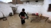 A boy rescues belongings from a flooded home after heavy rains in Peshawar, Pakistan, in April.
