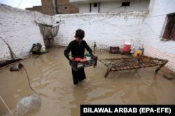 Dječak iznosi stvari iz poplavljenje kuće u Peshawaru, Pakistan, 15. april 2024.