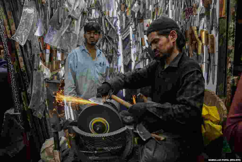 An Afghan blacksmith sharpens knives for sale in Kabul.&nbsp;