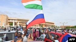 Supporters of Niger's National Council for the Safeguard of the Homeland wave Nigerien and Russian flags as they demonstrate in support of the military coup in Niamey on August 6.