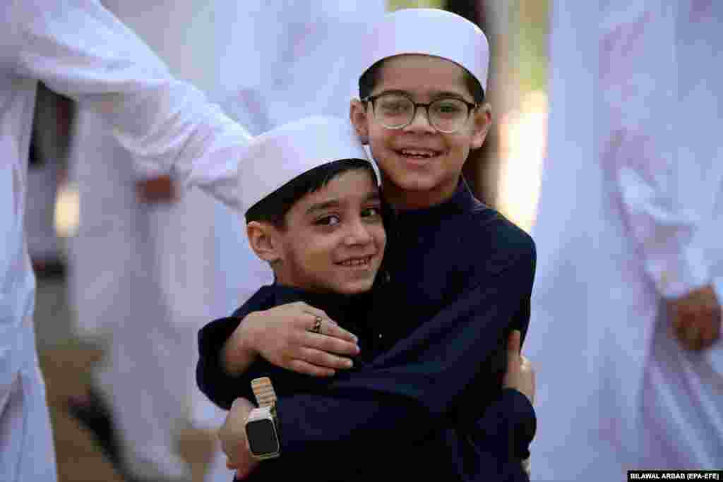 Мусульманские дети поздравляют друг друга после молитвы в Пешаваре, Пакистан.