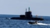 یک قایق نظامی، یک زیردریایی ارتش اسرائیل را در نزدیکی سواحل حیفا در دریای مدیترانه اسکورت می‌کند