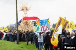 Muškarac nosi plakat dok ljudi marširaju tokom demonstracija koje je sazvao kolektiv "Bassines Non Merci" na gradilištu nove infrastrukture za skladištenje vode za poljoprivredno navodnjavanje u zapadnoj Francuskoj, u blizini Sainte-Soline, Francuska, 25. marta, 2023. Na plakatu piše: "Niti jedan bazen više".