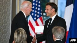 Президент Франції Емманюель Макрон (справа) тисне руку президенту США Джо Байдену під час державного візиту президента США до Франції, 8 червня 2024 року