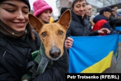 Женщина с собачкой у памятника Тарасу Шевченко, где собирались люди в знак поддержки Украины. Алматы, 24 февраля 2024 года