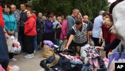 Rușii evacuați din zona în care se dau luptele în timpul incursiunii Ucrainei în Rusia se aliniază pentru a primi ajutor umanitar la un centru de distribuție din Kursk, pe 12 august.