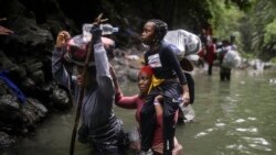 Хора от Хаити преминават през река, докато пресичат прохода Дариен между Колумбия и Панама с надеждата да стигнат до САЩ, 9 май 2023 г. 