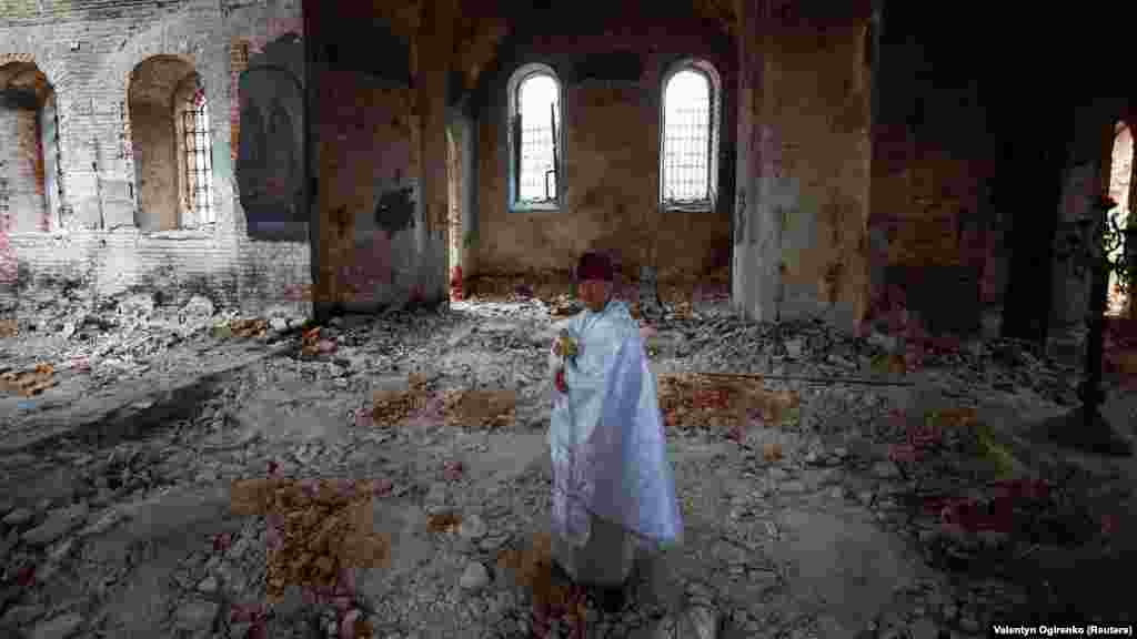 Egy ortodox pap, Szerhij atya áll a súlyosan megrongálódott templomban az ortodox húsvét alkalmából tartott istentisztelet után Lukasivkában április 16-án